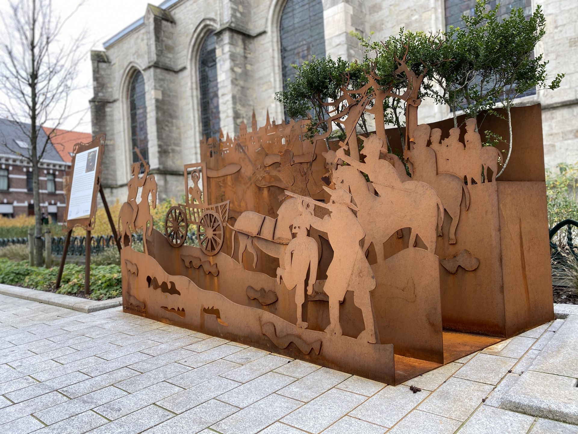 Cortenstalen kunstinstallatie met uitgesneden figuren bij de Sint-Martinuskerk
